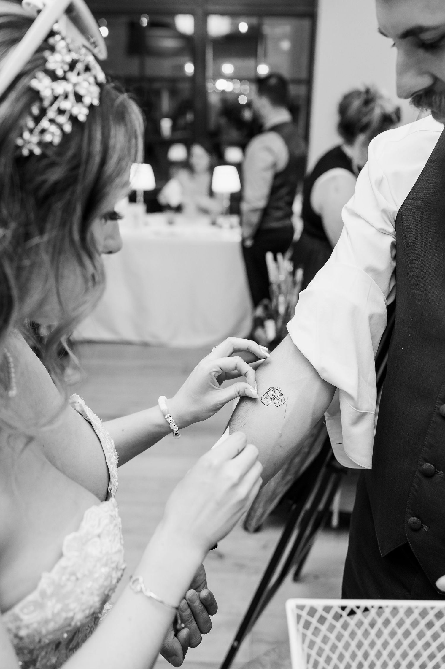 Black and white photo of wedding couple participating in reception activities.