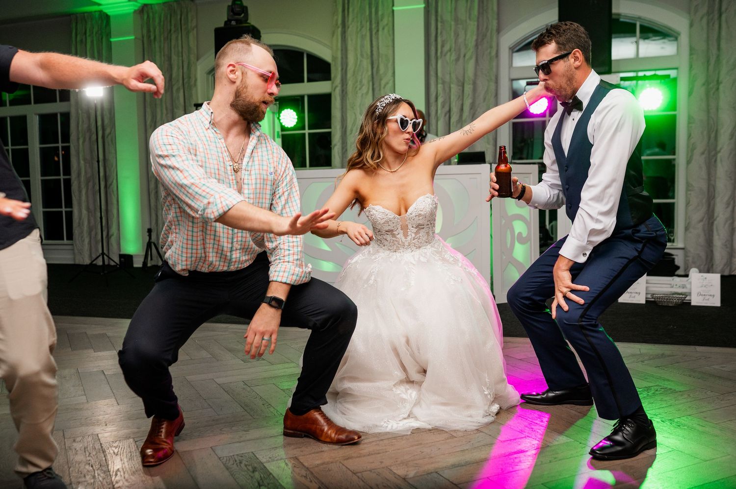 Dynamic dance floor shots showing wedding guests in motion under colorful lighting.