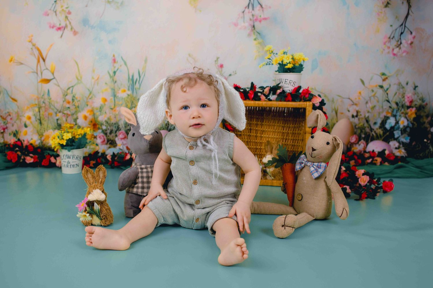 A baby in a pink dress sits with a teddy bear in a series of sweet studio portraits.