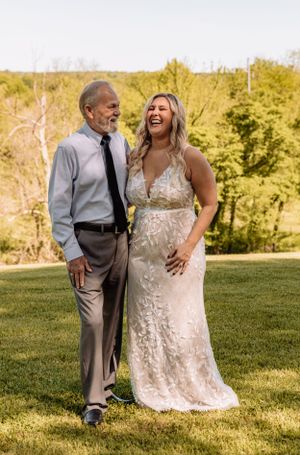 A couple shares a joyful moment outdoors during a wedding photoshoot.