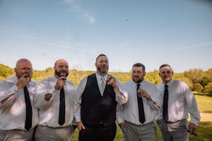 Group of men in formal attire having fun during outdoor photo session.