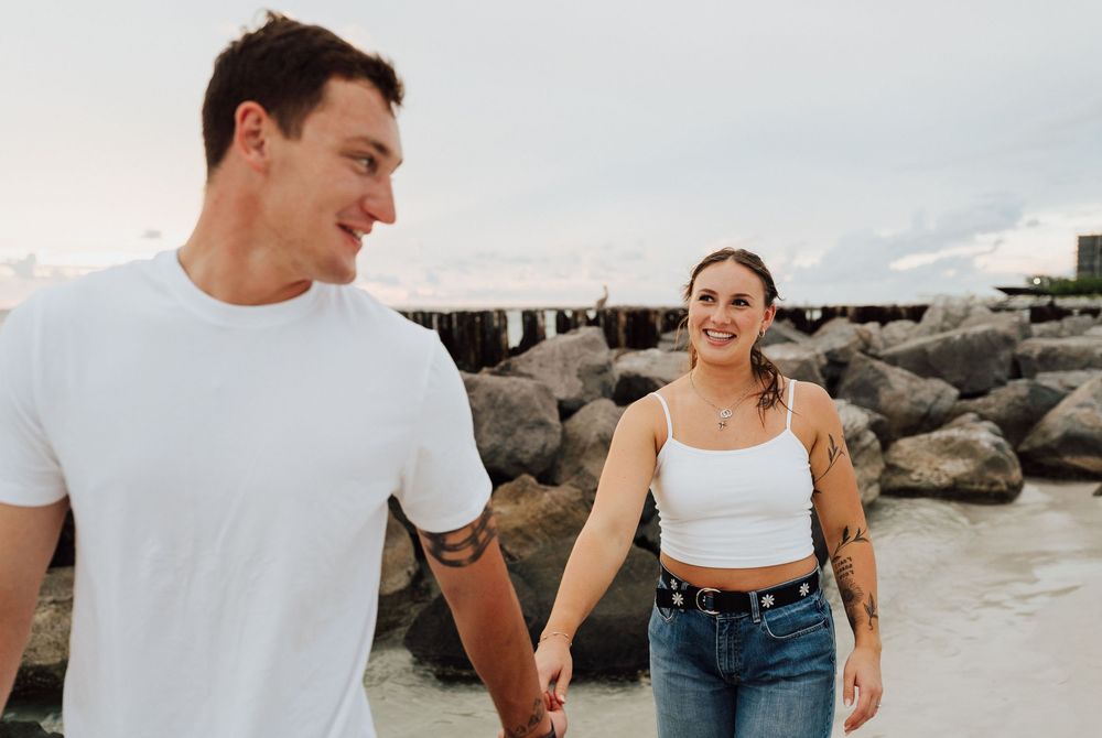 Engagement photoshoot on St. Pete Beach with a coastal sunset as the background. Romantic Tampa Bay coastal vibes.