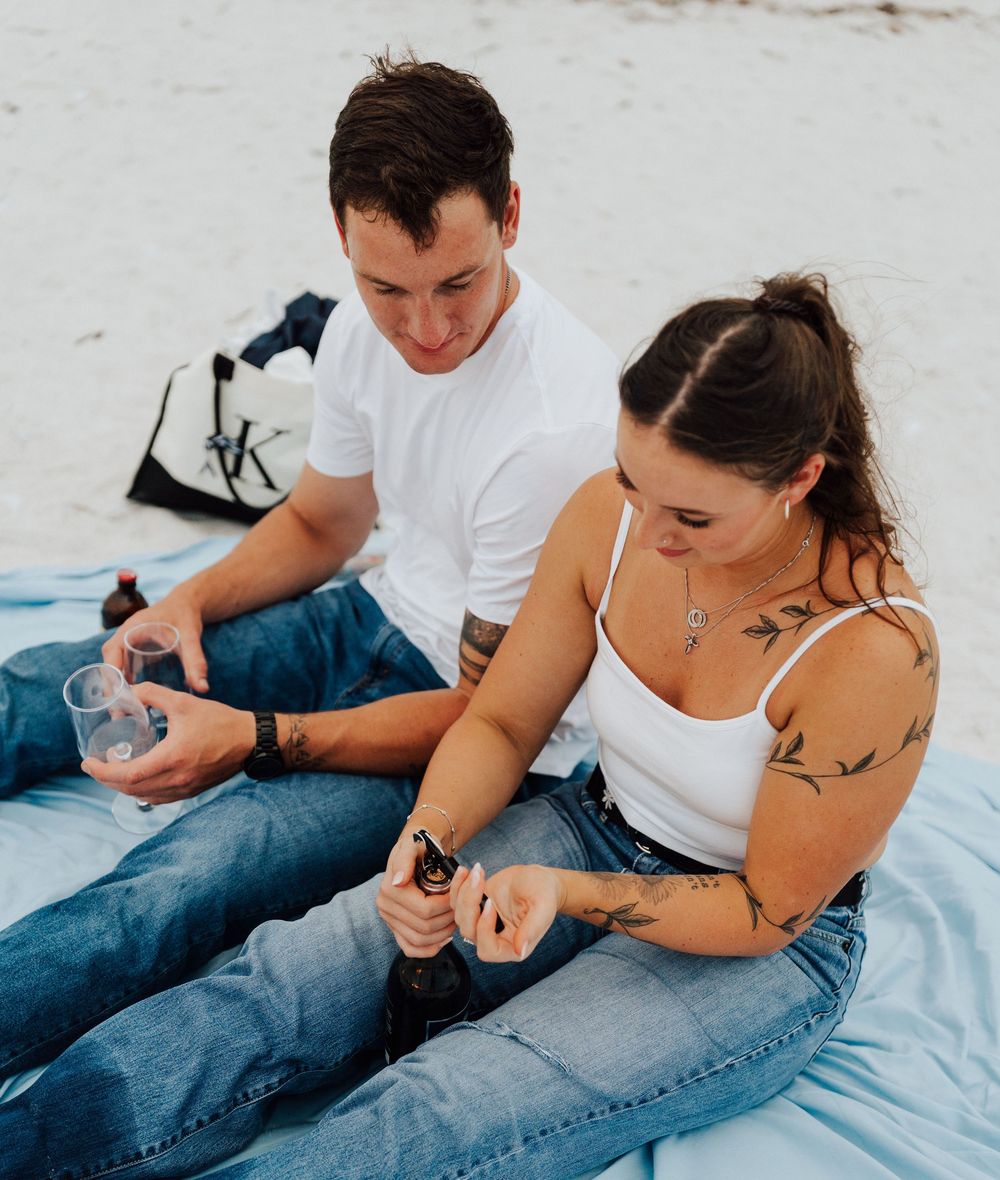Engagement photoshoot on St. Pete Beach with picnic setup, wine, and relaxed Tampa Bay coastal vibes.