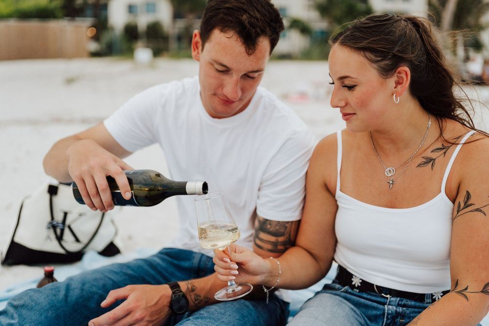 Engagement photoshoot on St. Pete Beach with picnic setup, wine, and relaxed Tampa Bay coastal vibes.