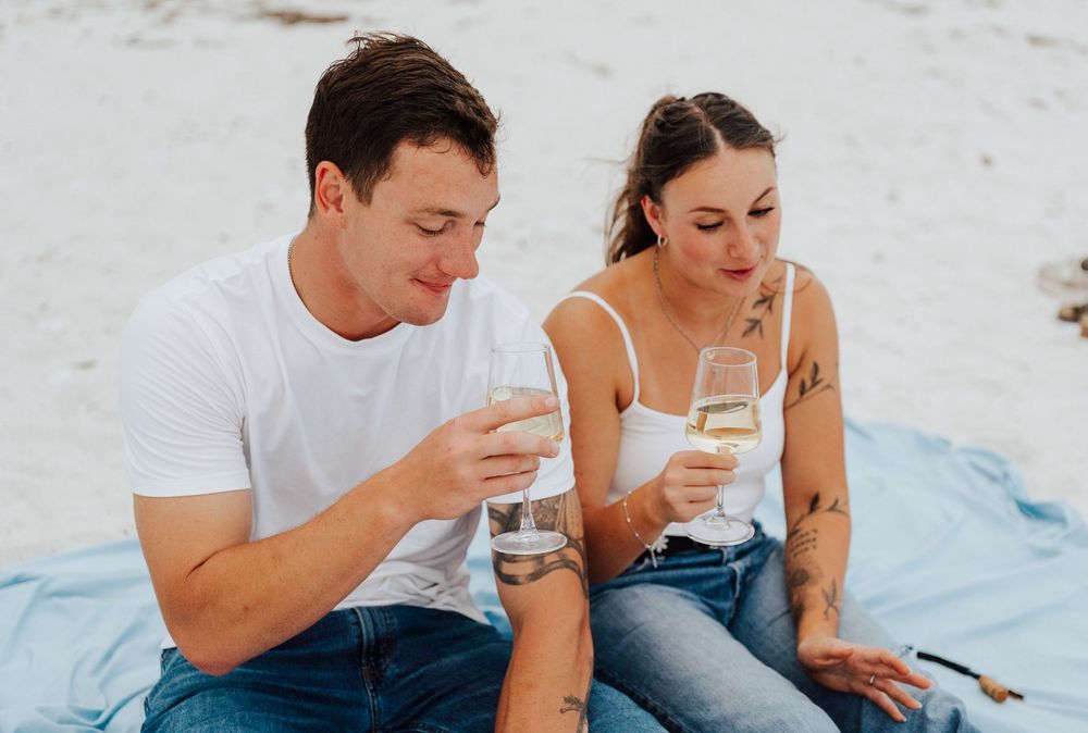 Engagement photoshoot on St. Pete Beach with picnic setup, wine, and relaxed Tampa Bay coastal vibes.