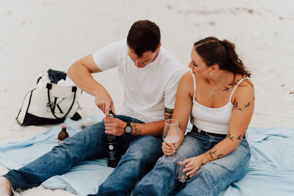 Engagement photoshoot on St. Pete Beach with picnic setup, wine, and relaxed Tampa Bay coastal vibes.