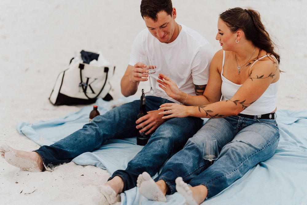 Engagement photoshoot on St. Pete Beach with picnic setup, wine, and relaxed Tampa Bay coastal vibes.
