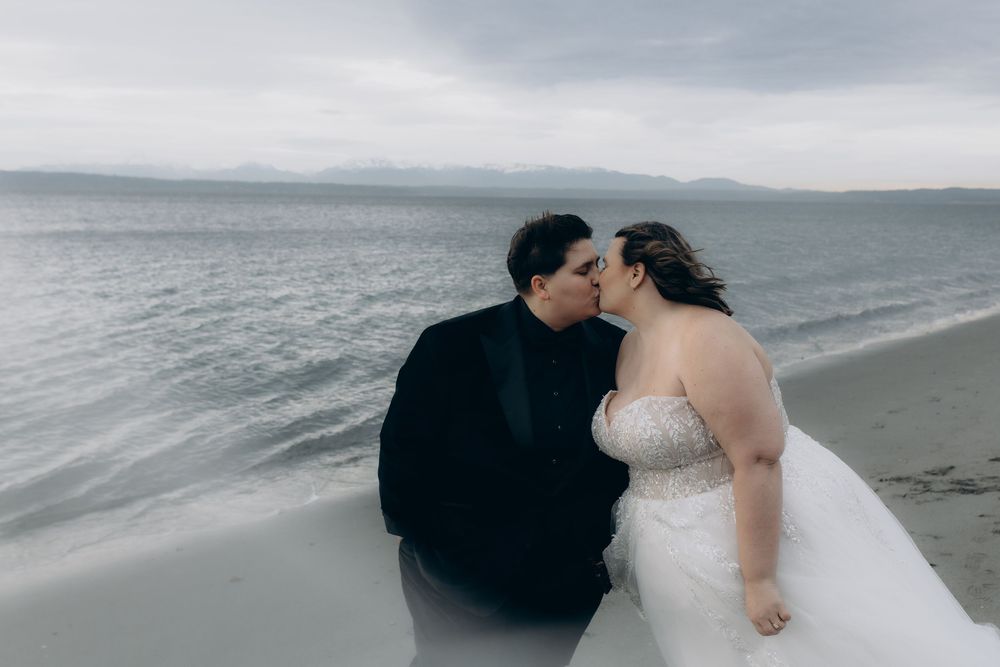 A romantic beach wedding photo shoot with a couple walking along the shoreline at sunset.