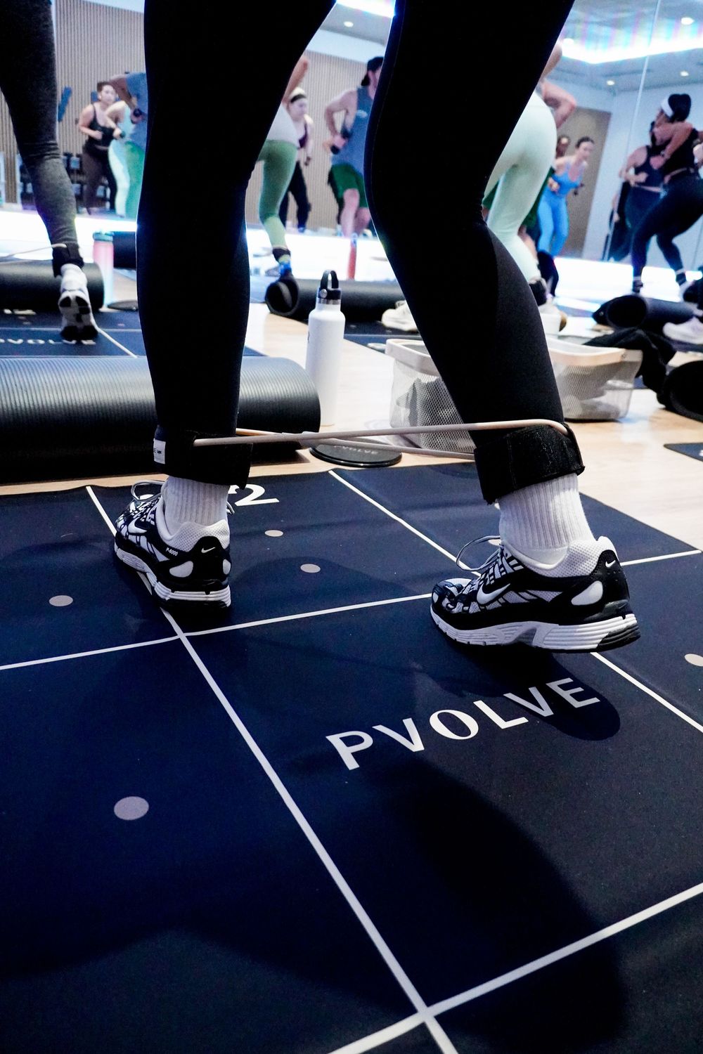 A series of feet in black shoes stepping on dark floor panels with white text markings showing interactive movement.