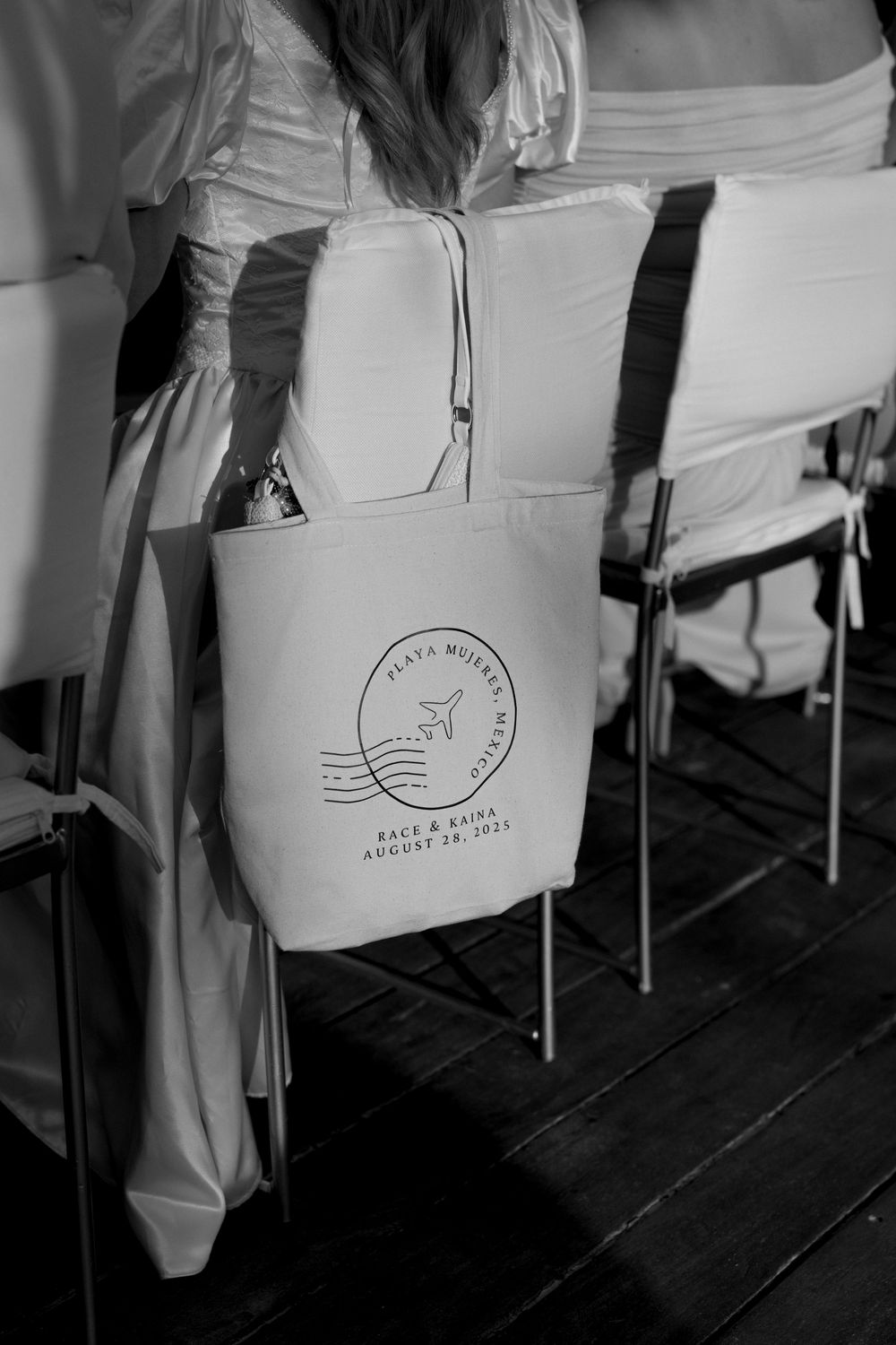 Restaurant chairs with white covers featuring a coastal themed logo at a beachside dining venue.
