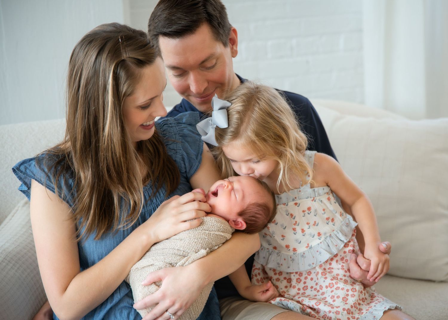 Loving parents share tender moments with their newborn baby in a series of intimate home photographs.