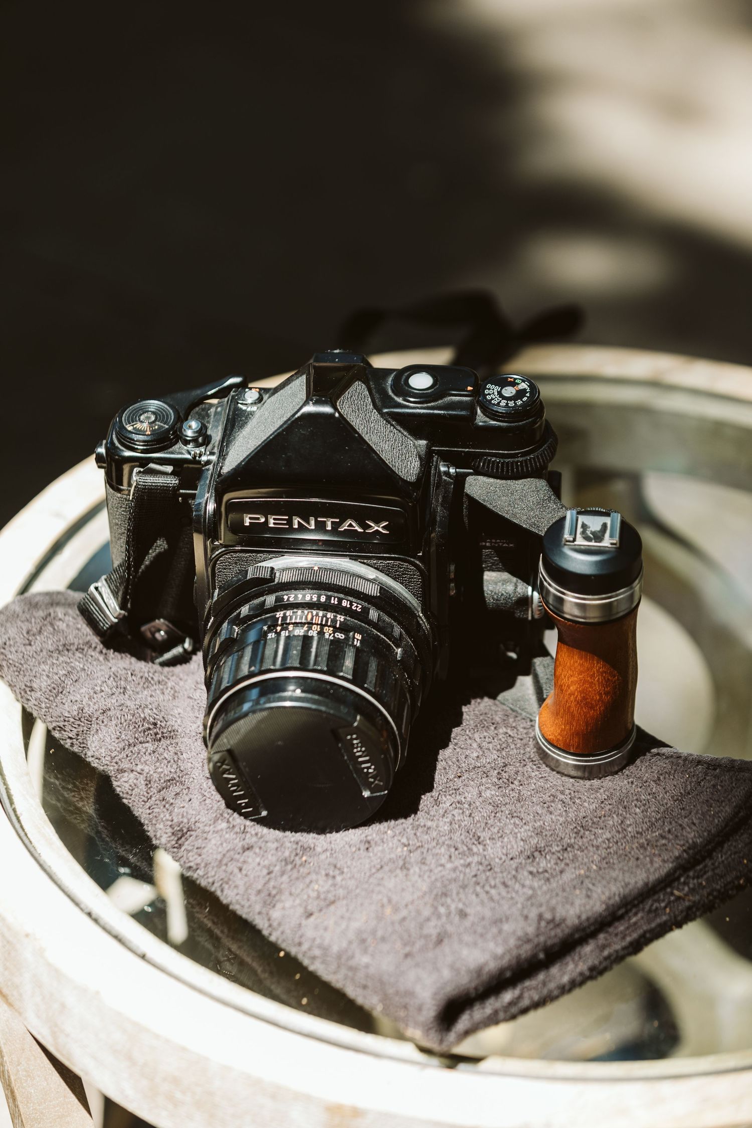 Vintage Pentax film camera displayed on gray fabric in multiple artistic angles.