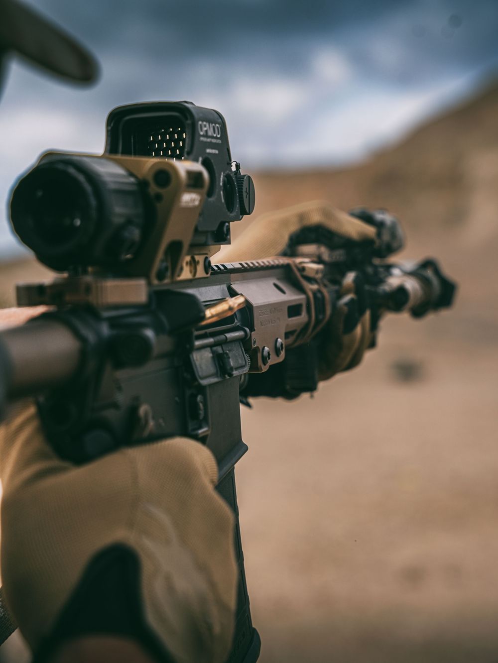Close-up view of a mounted rifle scope on a tactical firearm showing precise optical equipment in sepia tones.