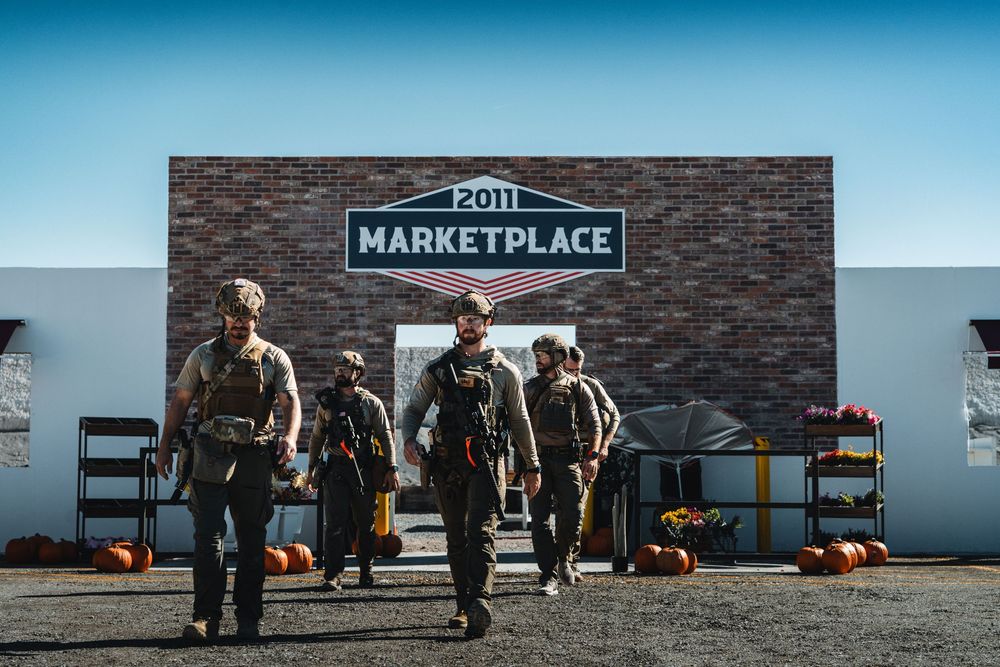 A squad of highly trained swat officers walking away from a market front.