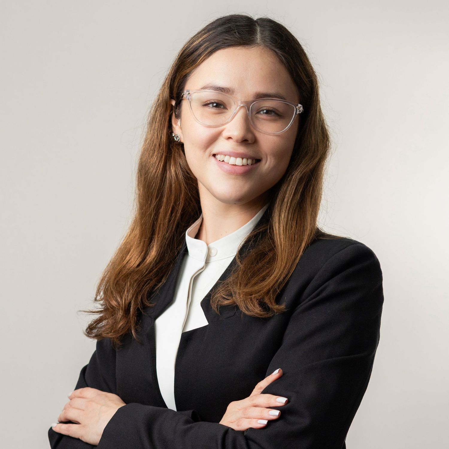 Professional in a black blazer and white shirt poses confidently against a light background in multiple poses.