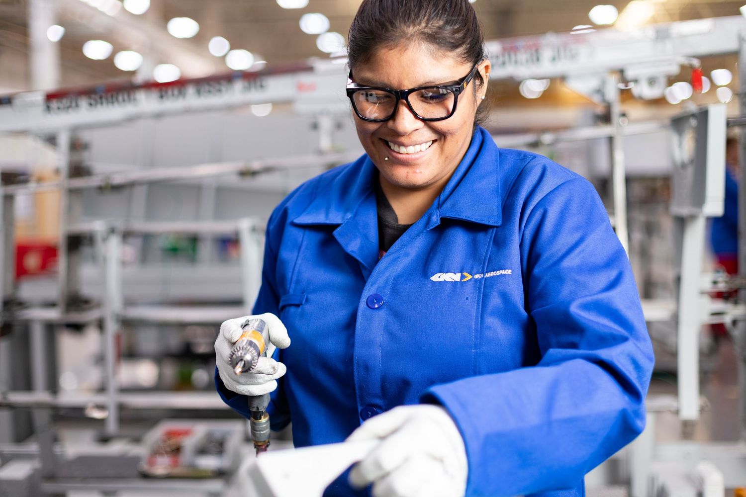 Warehouse employees in blue uniforms working with packages in a bright industrial setting.