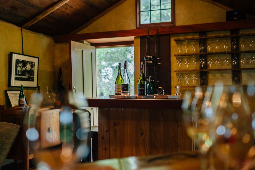 Bar area of a wine tasting room with glass displays and wooden accents.