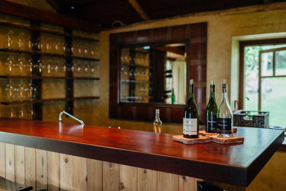 Modern wine bar interior with glass racks and counter seating.