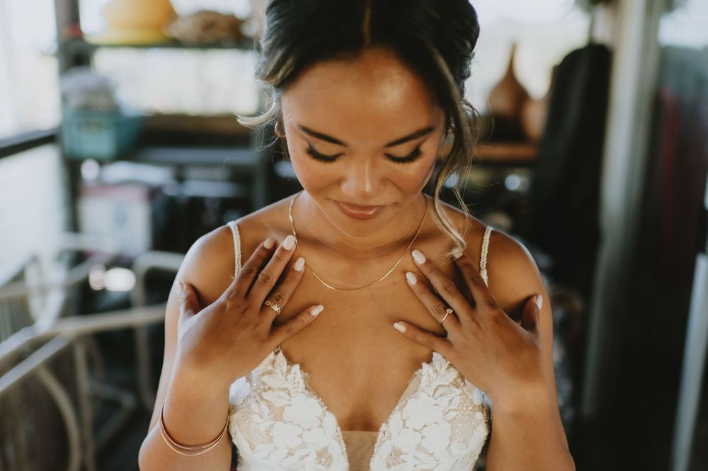 Close-up of bride showing off engagement ring and wedding dress details.