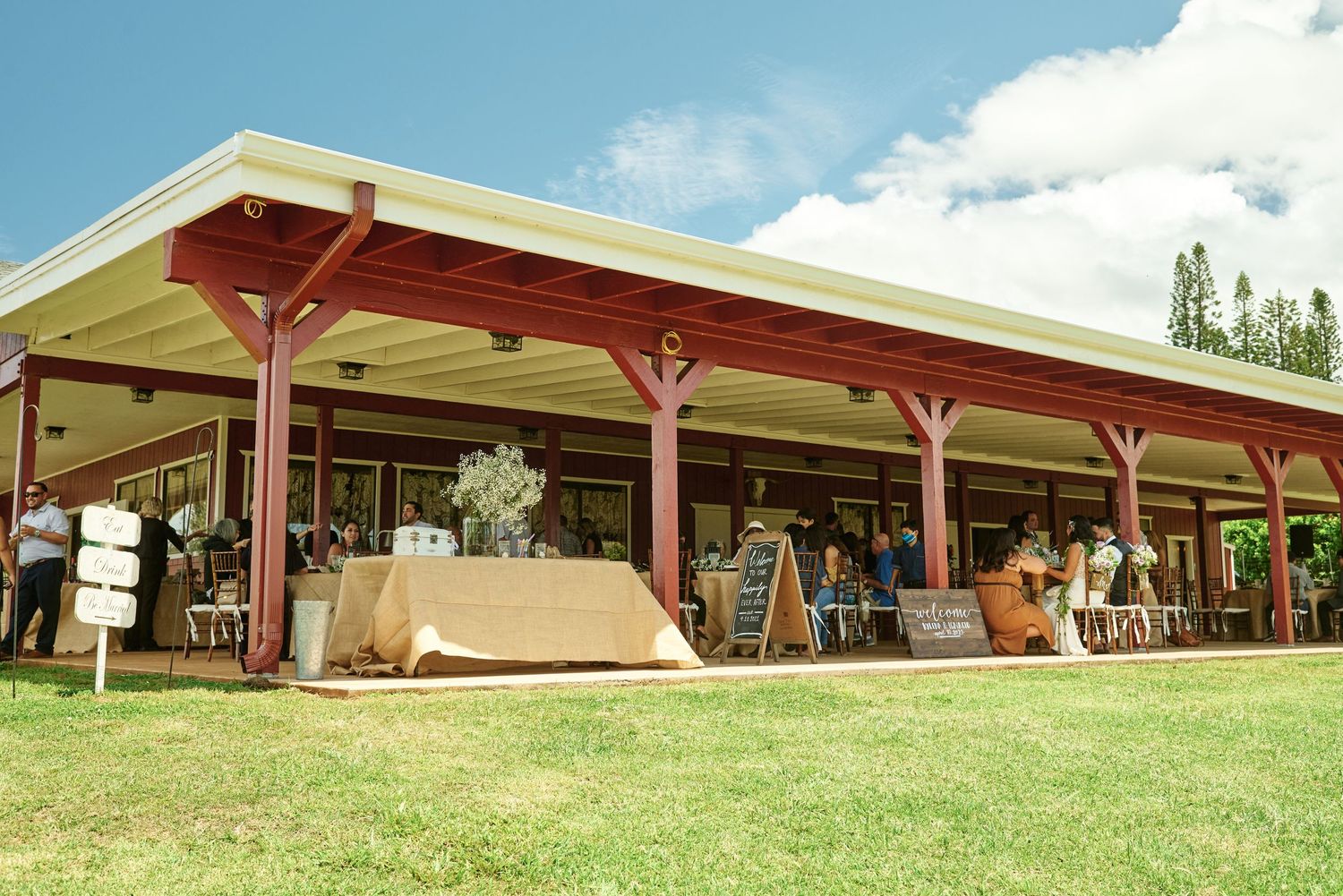 Long covered outdoor pavilion venue set against green rolling hills.