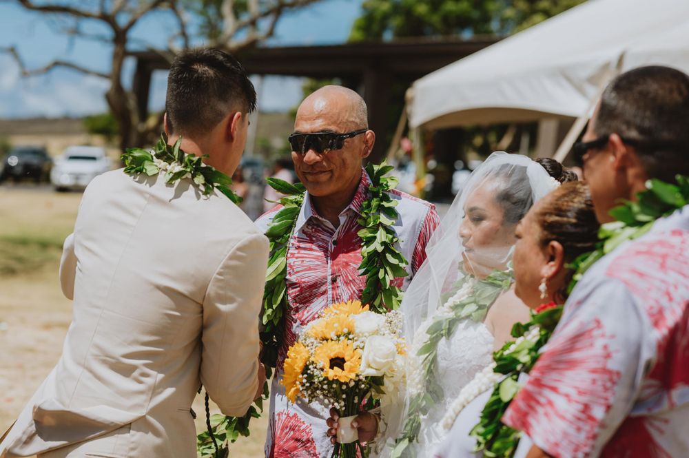 Wedding celebration with guests wearing traditional Hawaiian leis.