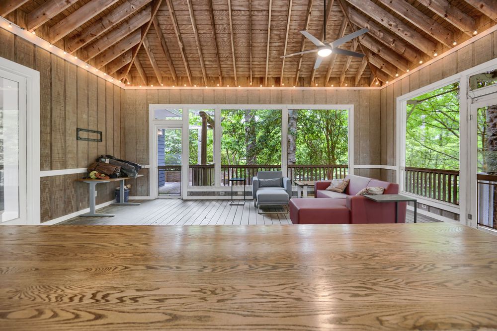 Large wooden yoga studio interior with exposed beams, hardwood floors and natural light streaming through windows.