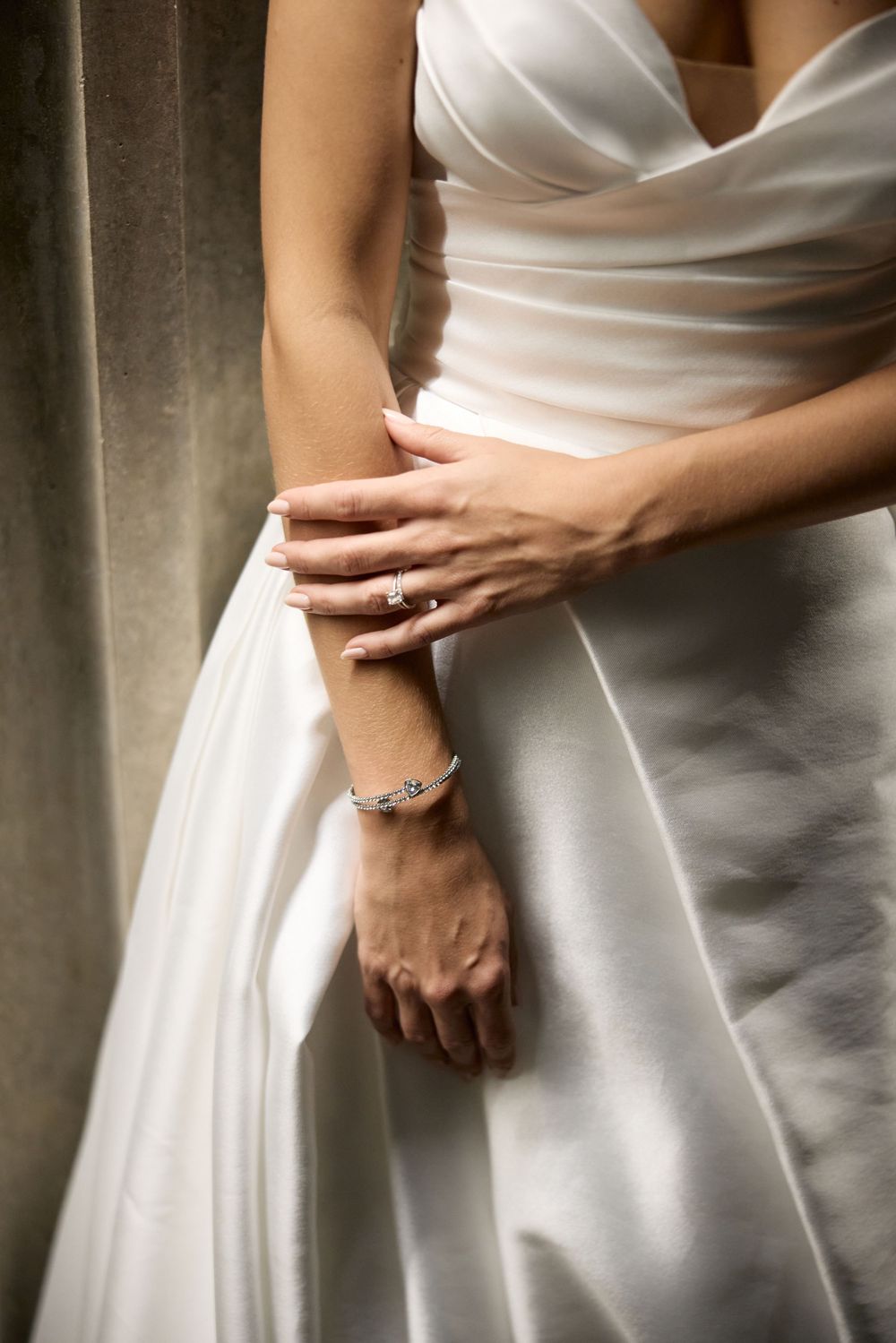 Close-up detail shots of a white wedding dress showing the fabric texture and elegant draping.