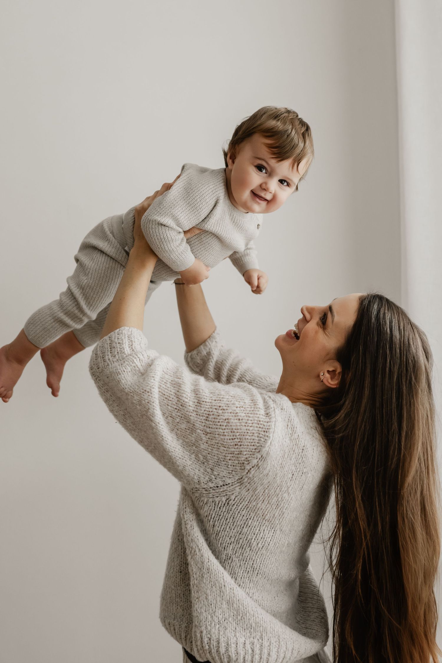 Herziges Foto von Mama & Kleinkind beim Kuscheln, Spielen und Spaß haben während eines Mommy & Me Fotoshootings im Fotostudio Stockerau