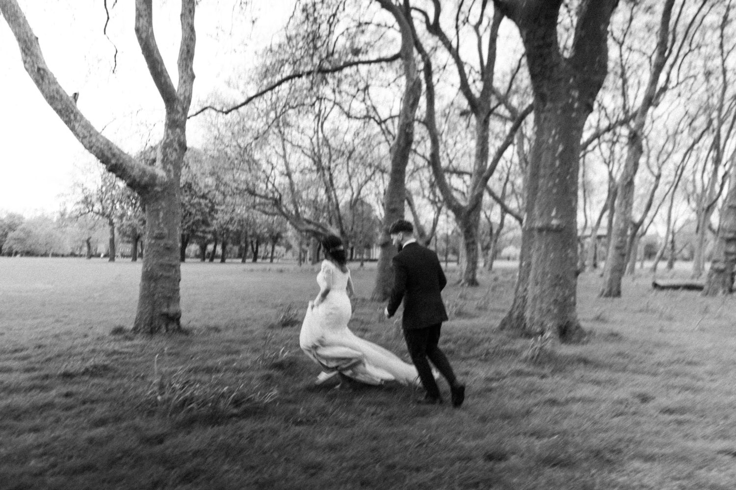 bride & groom running on a field, motion blurred wedding photo