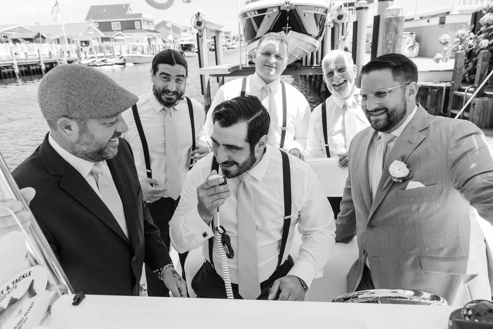 A group of people in formal attire gather around and examine documents at an outdoor event.