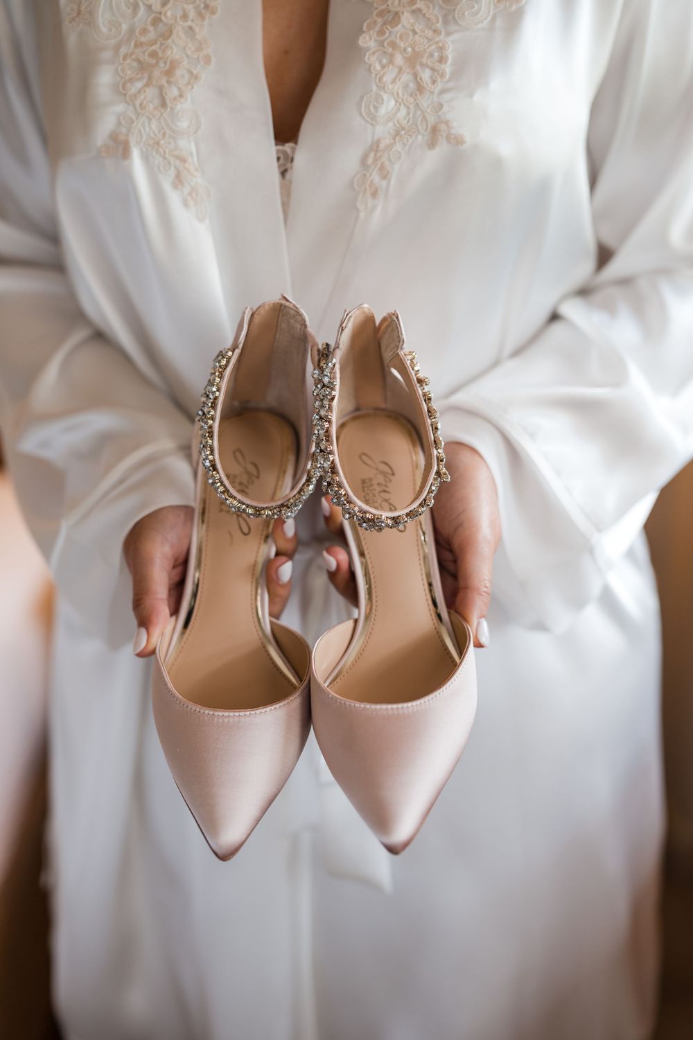 Bride holding her wedding shoes