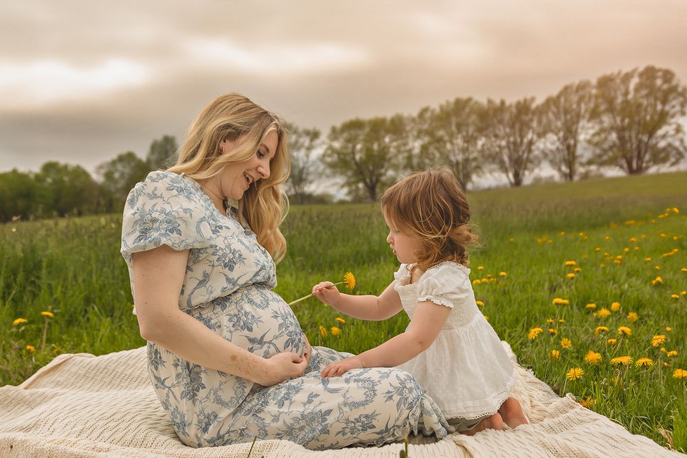 A peaceful moment shared on a blanket in a field of dandelions.