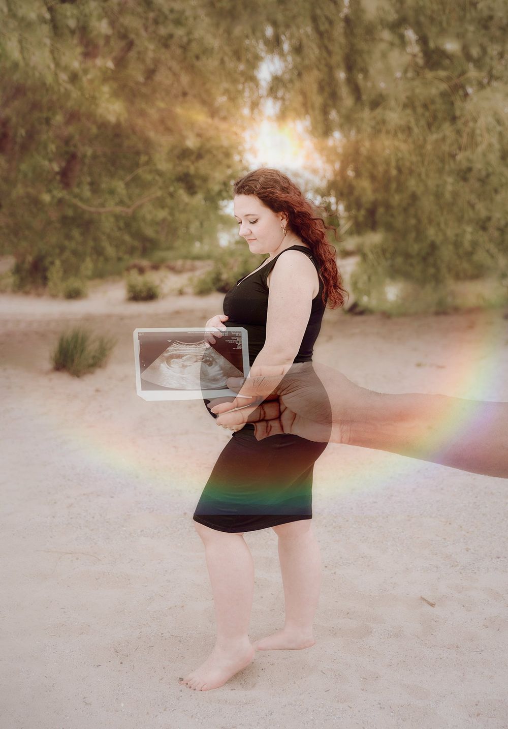 Woman in a dark dress holding a frame outdoors with a rainbow lens flare effect.
