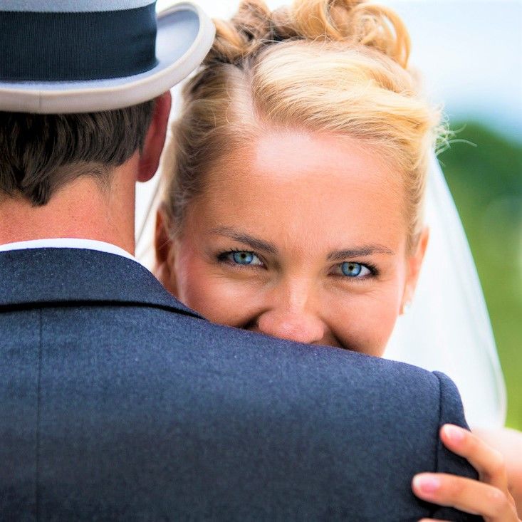 An intimate wedding moment captured with a close-up shot against natural outdoor lighting.