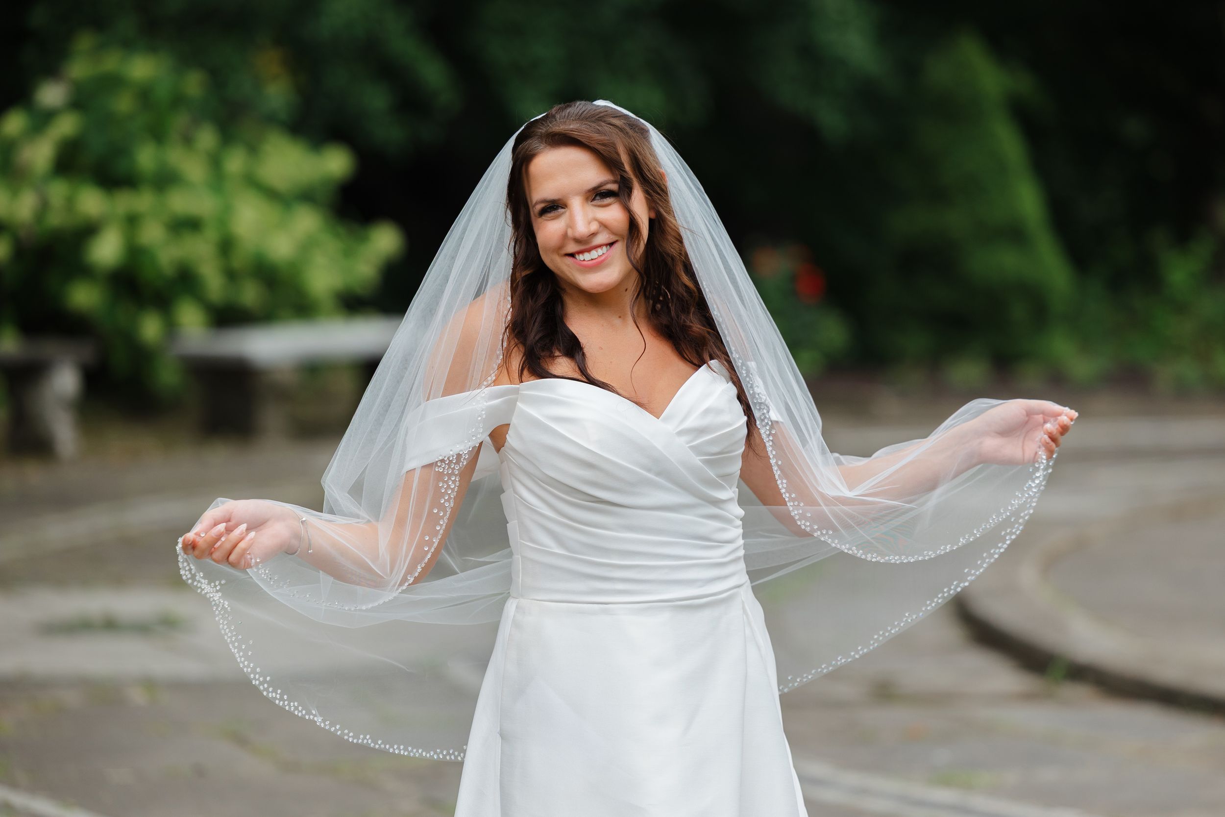 Bride holding veil at Italian Cultural Gardens in Cleveland.