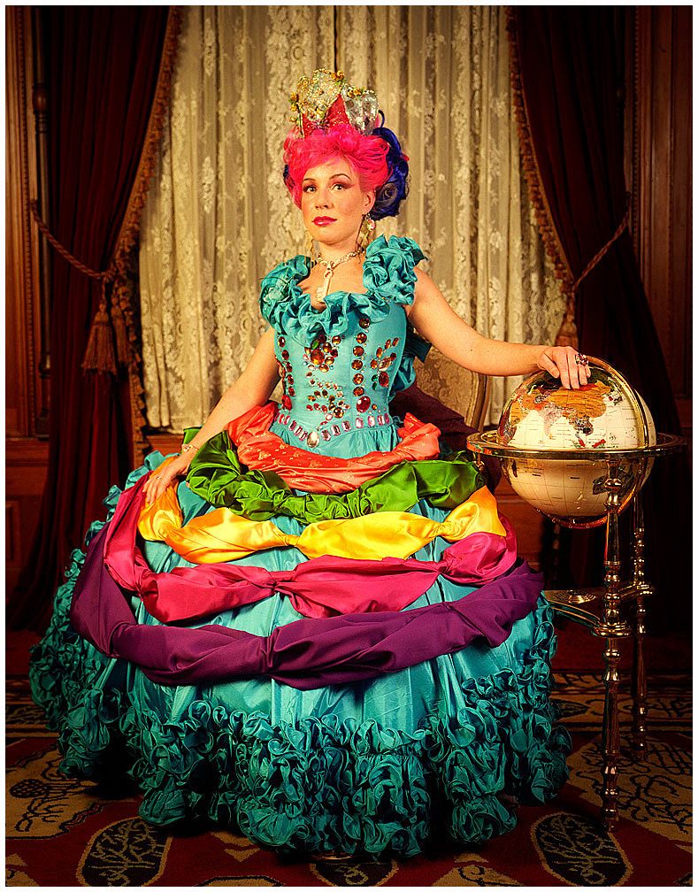 A colorful ruffled dress with vibrant turquoise, yellow, and pink tones photographed against an ornate interior backdrop.