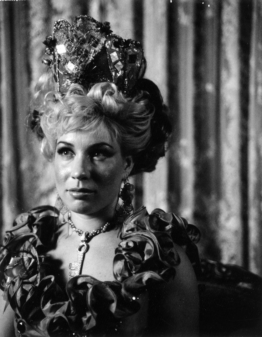 Black and white portrait series showing a person in theatrical makeup and ruffled costume against a striped background.