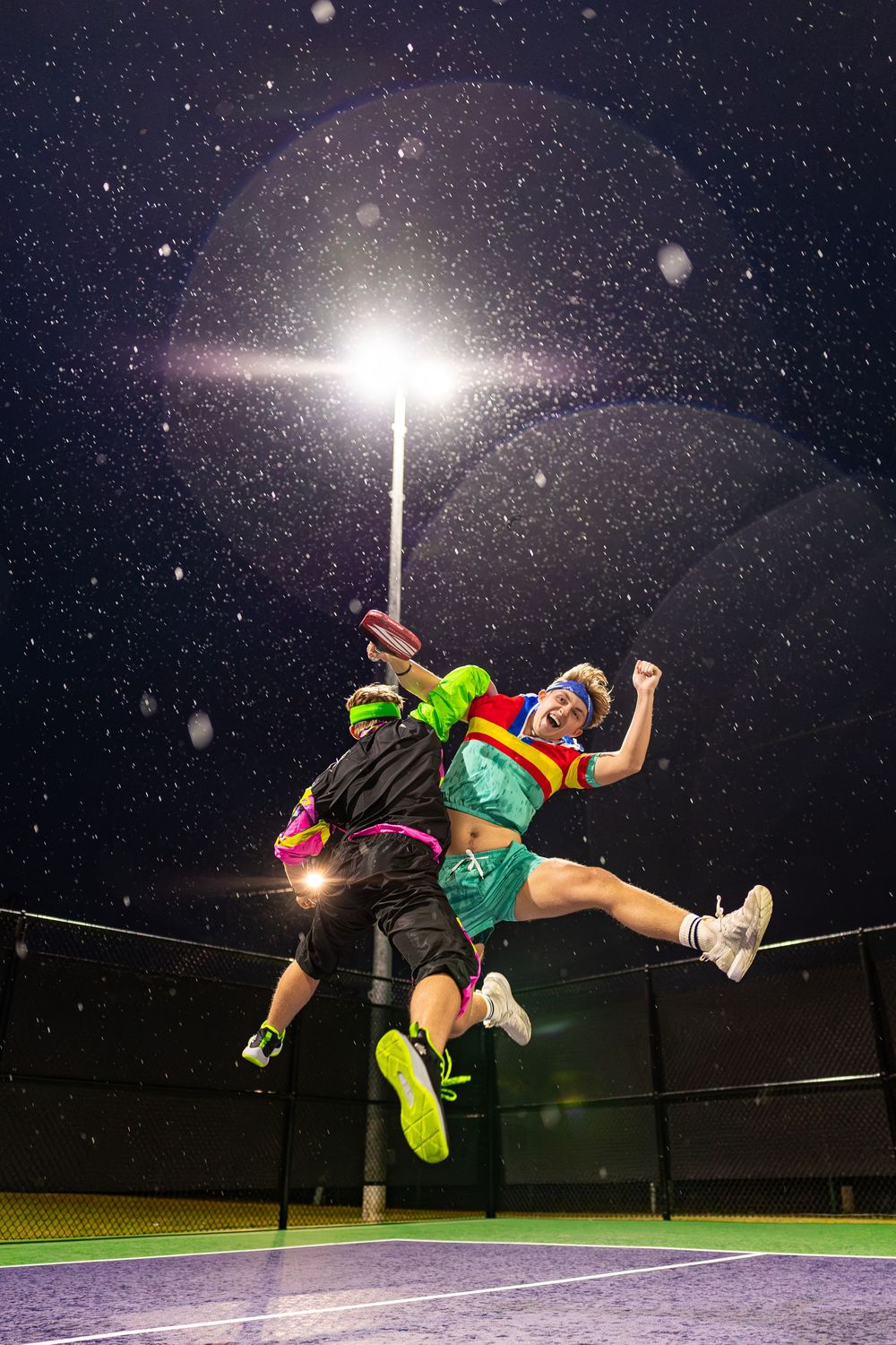 Dramatic nighttime action shots showing athletic jumps under bright stadium lighting.