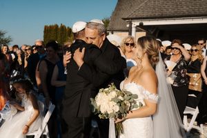 Wedding guests gather outside on a sunny day for a celebration with the newlyweds.