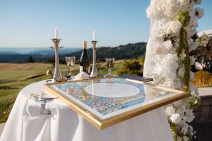 Outdoor infinity pool overlooking scenic mountain landscape with decorative floral arrangements and seating area.