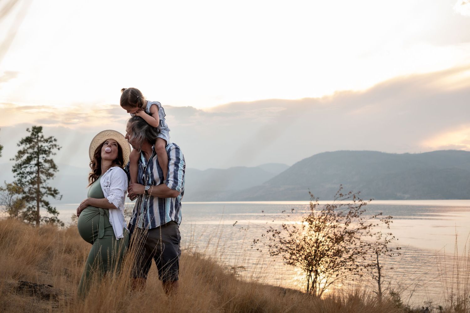 Group of people in cream colored sweaters posing among natural landscape.