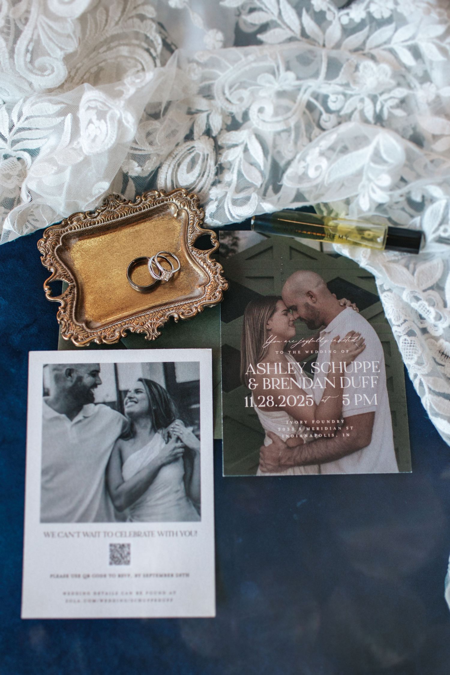 Wedding invitations and decorative frames displayed with white floral arrangements against a dark background.