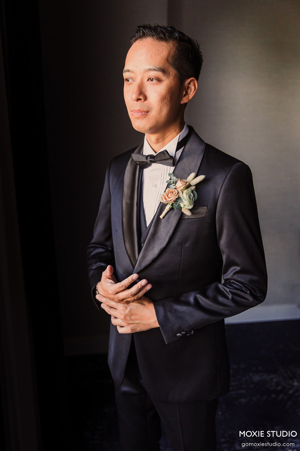 Professional portrait series of a groom in a classic black tuxedo with boutonniere against a dark background.