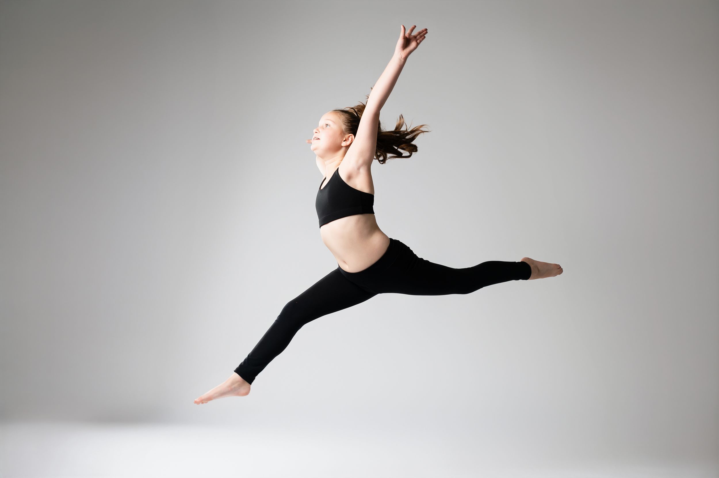 Modern dance sequence showing flowing movements in black attire against neutral backdrop.