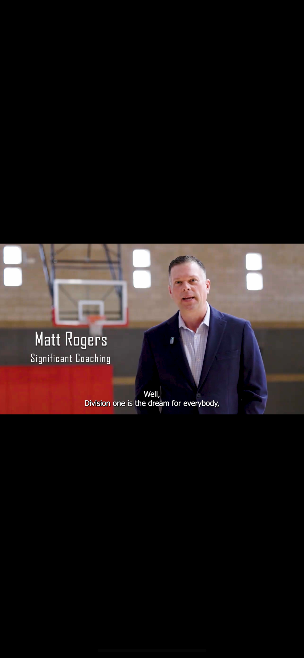 Professional wearing a blue suit jacket speaks in front of a basketball court with text overlay about coaching.