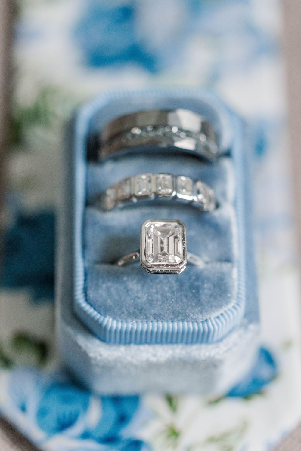 Three elegant diamond rings nestled in a powder blue velvet ring box.