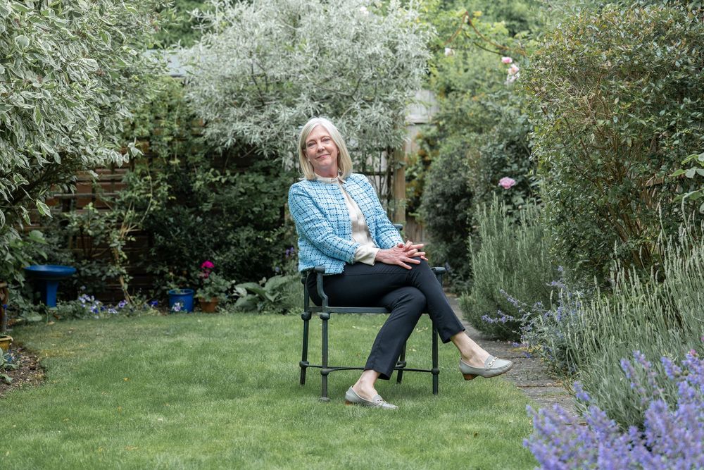 A relaxing scene in a lush garden with seating and blooming lavender flowers.