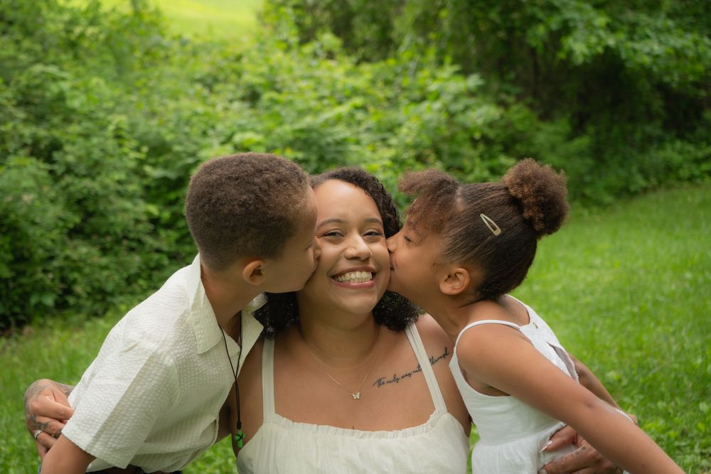 People enjoying an intimate moment together outdoors in a lush green garden setting.