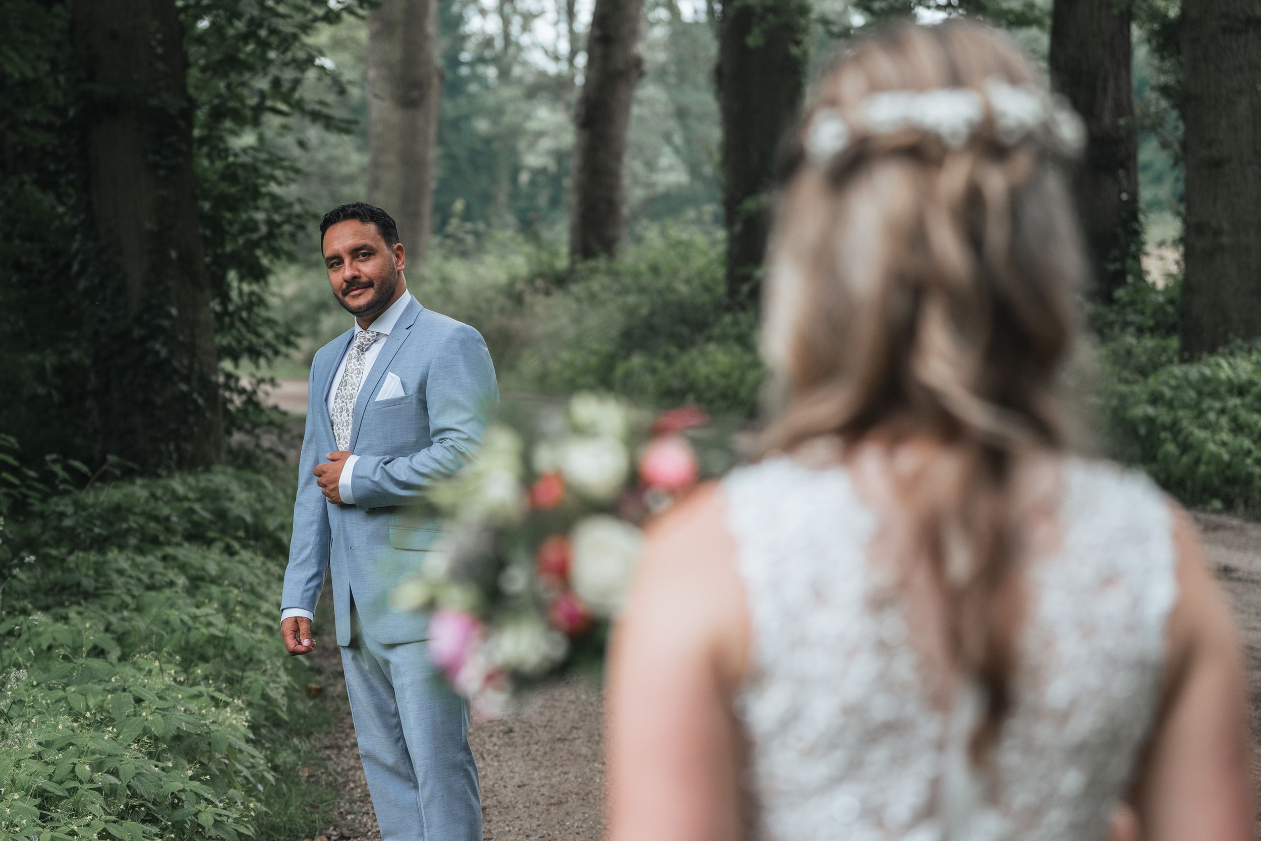A couple celebrates their wedding ceremony in a beautiful outdoor forest setting with natural lighting.