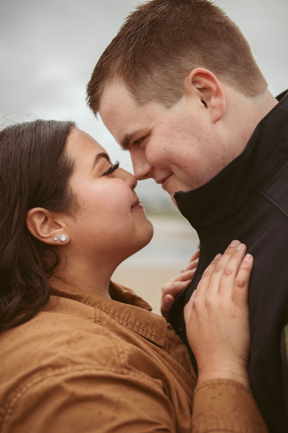 Close-up of a couple sharing an intimate moment against a neutral background in a series of sequential frames.